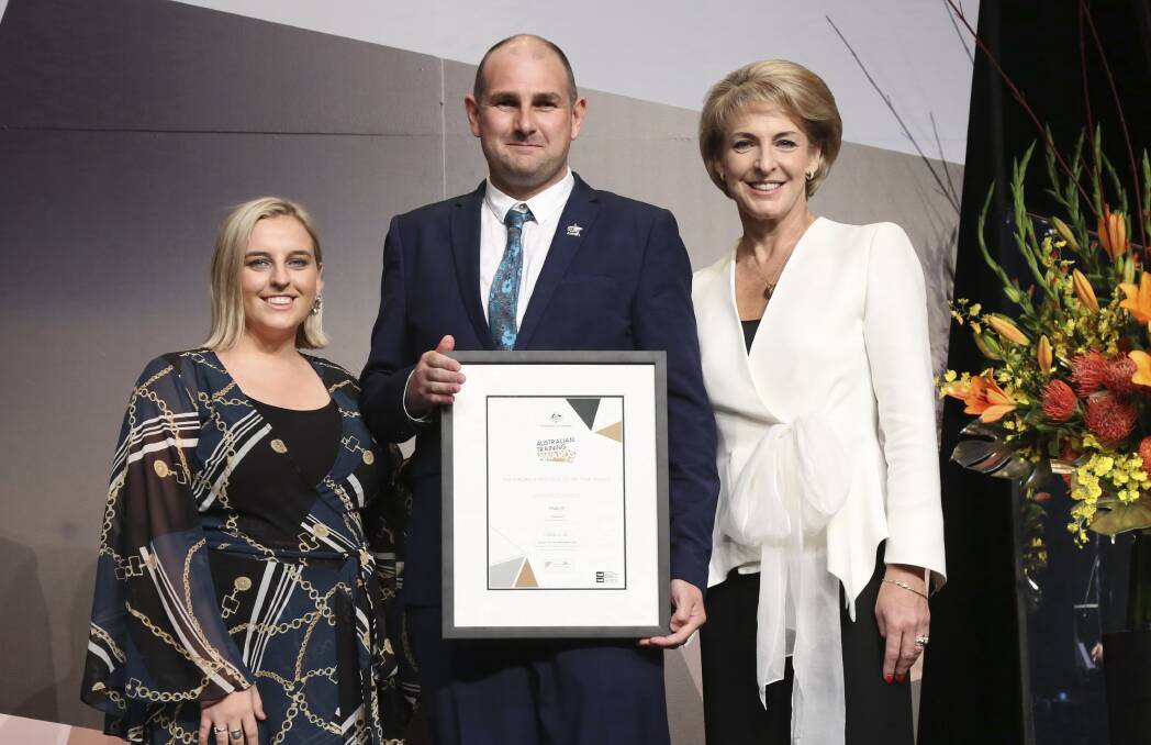 Humble hero: TAFE NSW Wagga Wagga student, Snowy Hydro apprentice electrician and Corryong resident Michael Edwards accepts his award for Apprentice of the Year at the Australian Training Awards from Federal Minister for Skills and Vocational Education Michaelia Cash (right) and last year’s Apprentice of the Year winner Gemma Hartwig. Photo: Trevor Connell, BAPCO media
