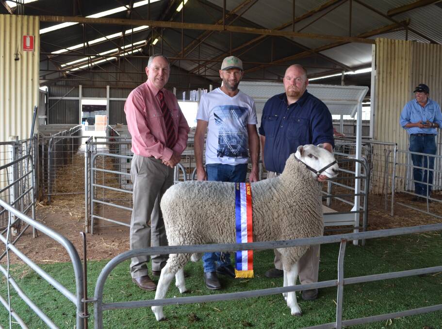 Elders auctioneer Paul Jameson, Mike King, South Australia and Ben Campbell holding onto the champion ram from Avoca Border Leicesters.