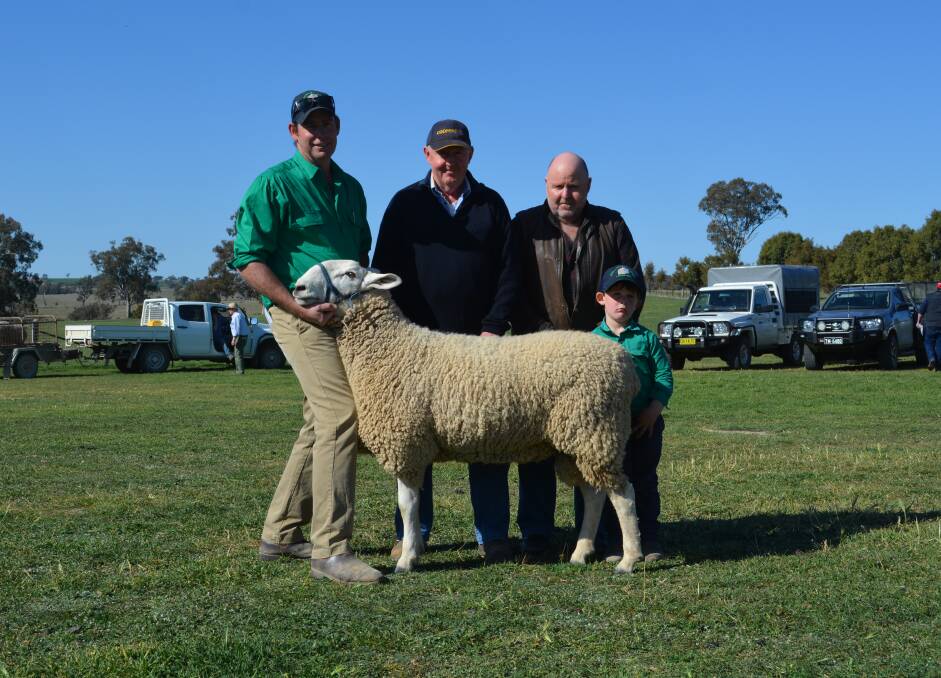 Normanhurst co-principal Tom Corkhill, Boorowa, holding the $3000 top-priced ram purchased by Michael and John Perabo, Allambi, Boorowa, pictured with four-year-old Finn Corkhill. 