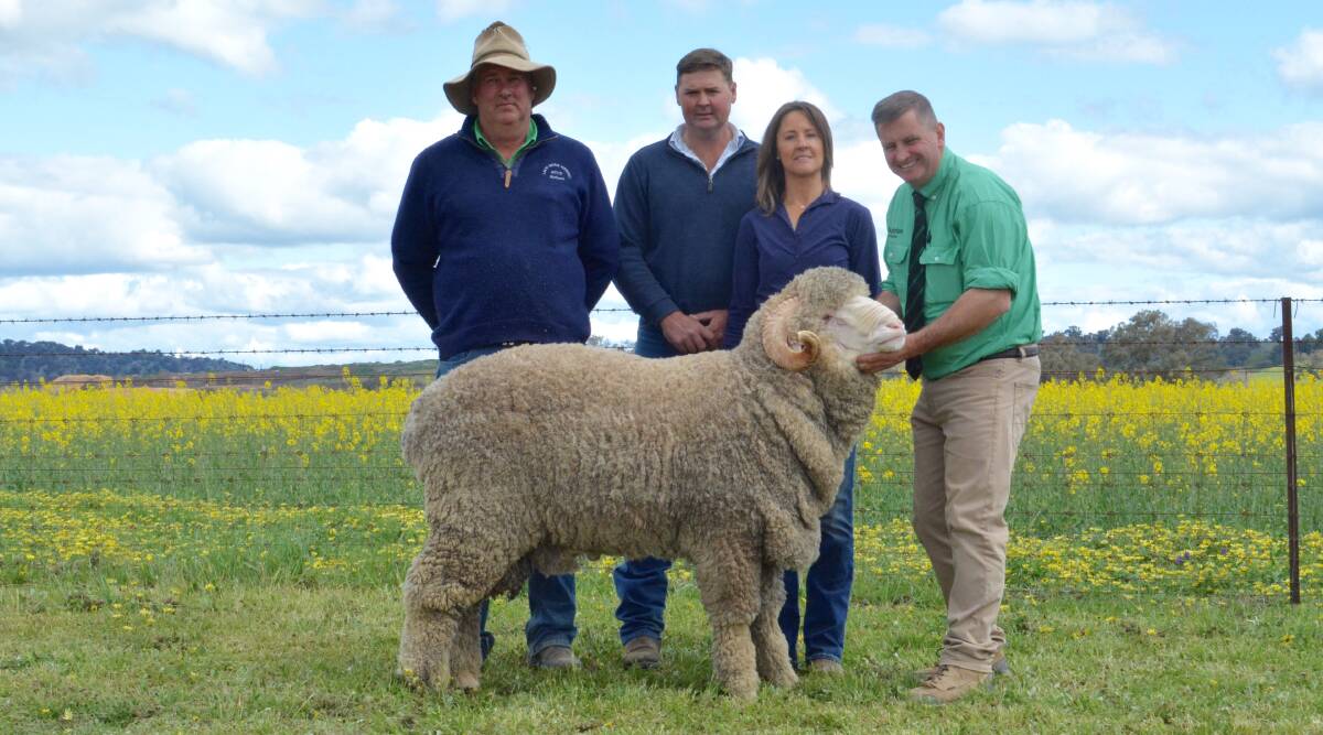 Richard Chalker of Lach River, Darby's Falls, with buyers of the $12,000 top-priced ram Mark and Jodie Pendergast, Cottage Park Merinos, Cooma, and auctioneer Rick Power, Nutrien. Photo: Hannah Powe