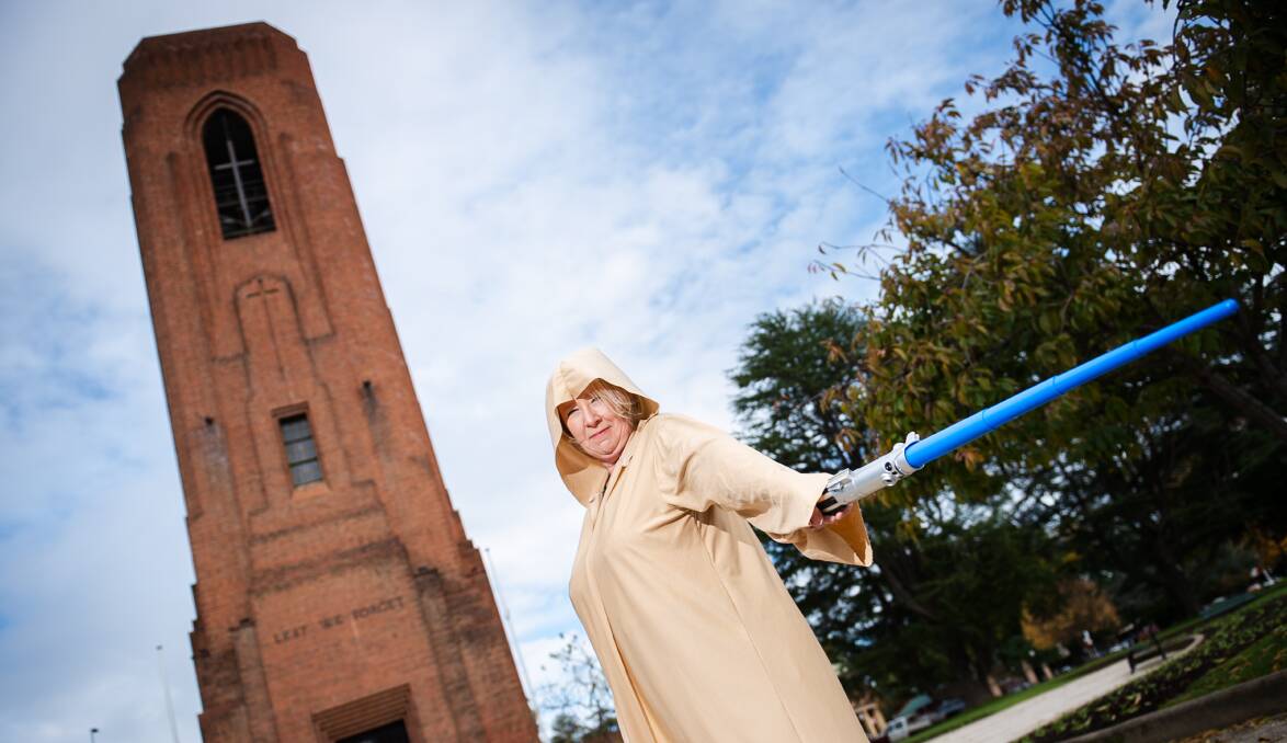 Wendy Murphy dressed in a Jedi robe and holding a lightsaber, while standing in front of the Bathurst War Memorial Carillon. Picture by James Arrow