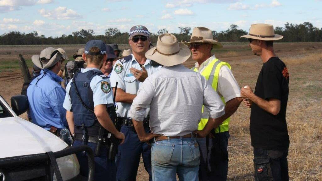 Police explain the law's nuances to farmers yesterday as a tense standoff developed.