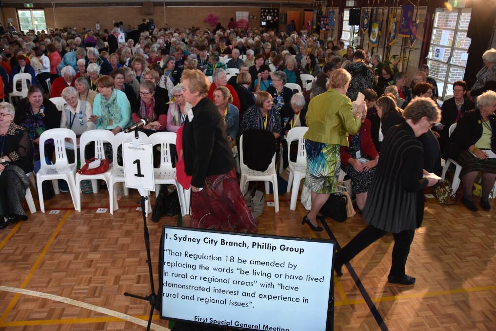 Country Women's Association move about in a break in proceedings with the proposed motion screened before them. The proposal to vary a long standing principle was defeated.
