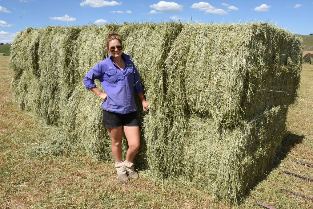 Stacey Matthews in front of some of the silage that came off her and husband Lee's paddocks on Tuesday.