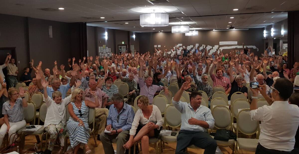 More than 400 people raise their hands to show they are against coal seam gas and they do not want a high-pressure gas pipeline built on the Western Slopes and Plains. 