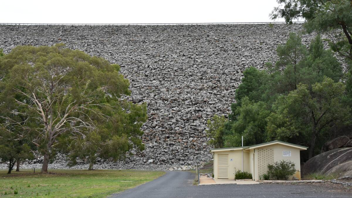 The wall dwarfs utility buildings near its base. Much of the existing park would likely be buried to extend the wall.