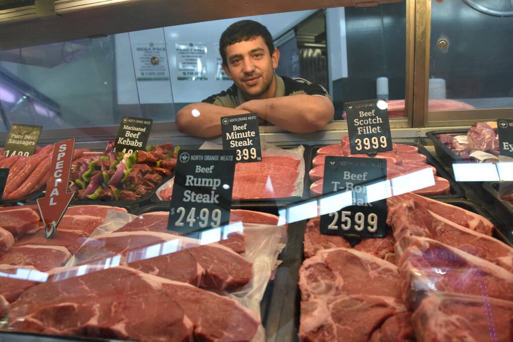 North Orange Meats employee Logan Powell with an array of beef on offer at the store. Owner Brad Baker said he'd been soaking up incremental price increases for the past month. Mr Baker said country people understood seasonal conditions better than their city counterparts. Photo: Daniel Pedersen