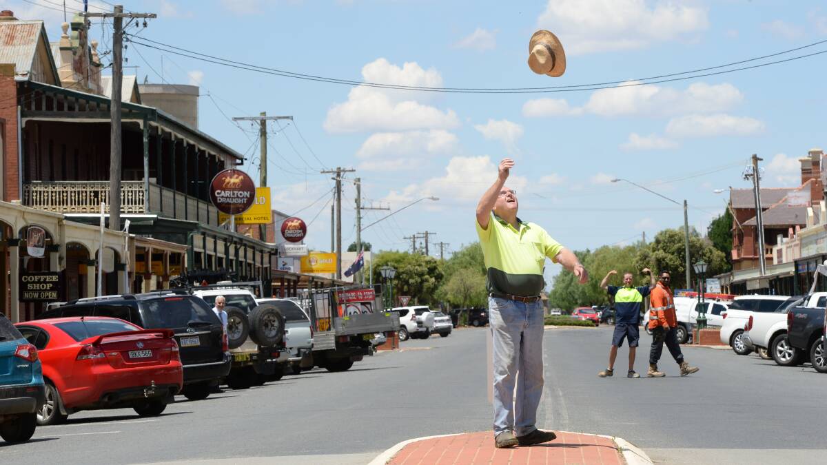 Lockhart Mayor Rodger Schirmer tosses his hat in the air as locals in the background give a sense of the town's pride at being a part of a pioneering energy project. Photo by Rachael Webb.