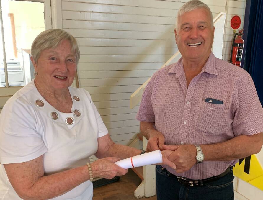 Maules Creek community member Joan Bradshaw hands the ceclaration to Narrabri councillor Ron Campey.