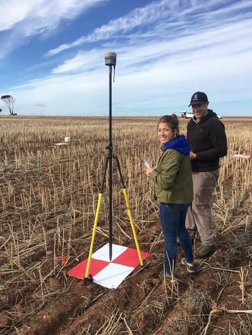 UWA student Justina Serrano with her supervisor Nik Callow and a drone used to take aerial imagery of ryegrass.