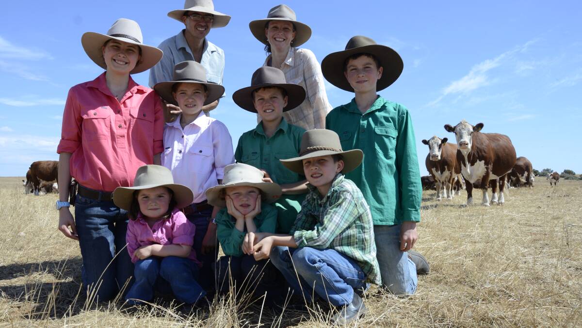 FAMILY AFFAIR: Mallee farmers Josh and Peri McIntosh (back) with their Border Park Organics Hereford beef herd and their seven children - (middle) Eliana, 14, Aleida, 10, Elias, 8, Abran, 12, (front) Aurelia, 2, Malachi, 4, and Gilead, 6.