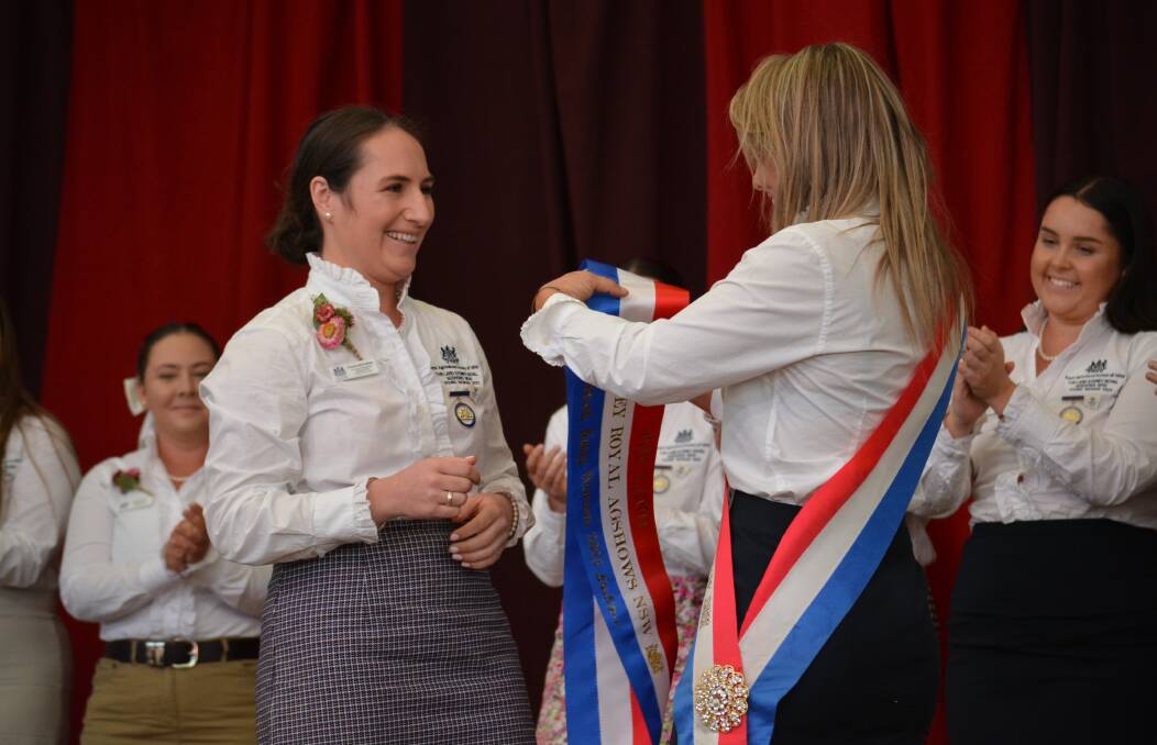 The 2022 The Land Sydney Royal Agshows Young Woman winner presents the 2023 sash to her successor, Florance McGufficke, Cooma, at this afternoon's presentation. Photos: Jessica Neale