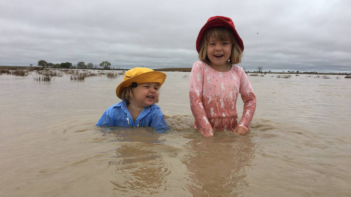 Two-year-old April Batt and her four-year-old sister Daisy Batt were nearly as happy as their parents when the creeks started to run muddy water at Hillview, Muttaburra after 50mm of rain on Saturday night. Photo by Ian Batt.