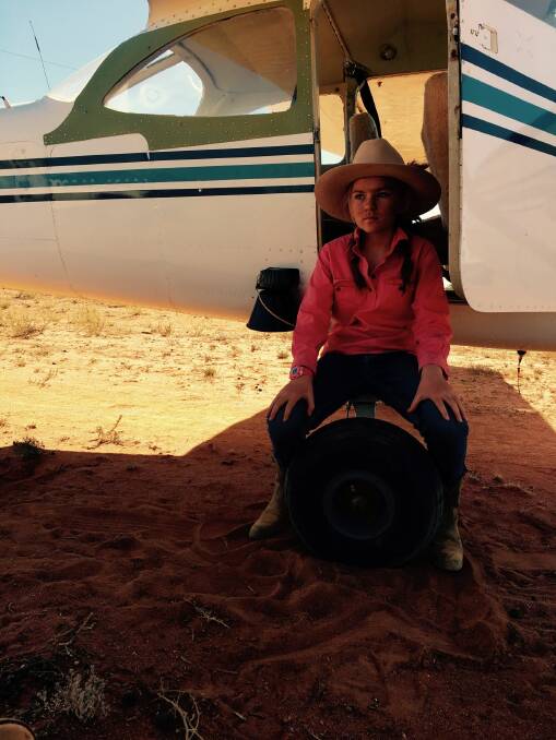 Stella Finch, 12, taking a smoko break from mustering under the plane wing. Photo by Laura Finch.