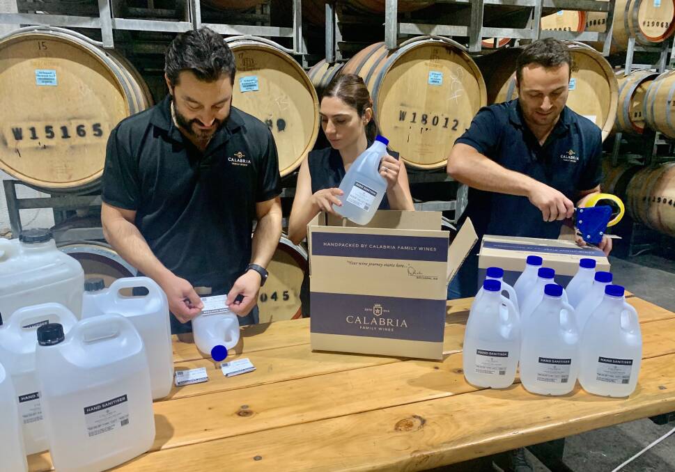 Michael Calabria, Elizabeth Calabria-Staltare and Andrew Calabria packaging hand sanitiser produced by the winery for health services. Photo: Calabria Family Wines