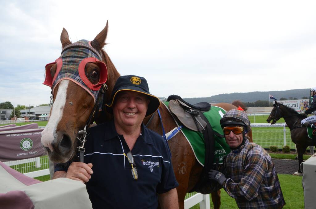 Paul Theobold grins after the win of Red Marauder who is being unsaddled by winning hoop Alan Barton.    
