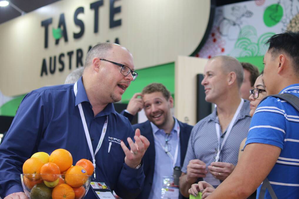 Growers speaking to customers at the Taste Australia stand at Asia Fruit Logistica.