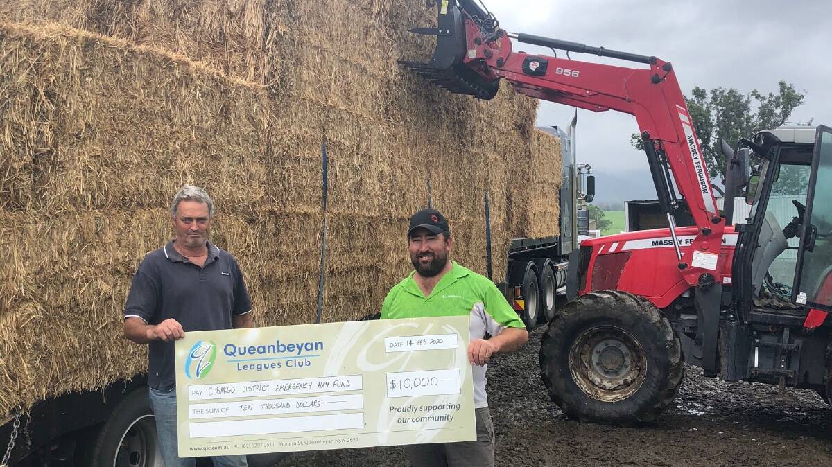 Dairy farmer Charlie Motbey and Rocky Allen receiving a load of hay from money raised through the Cobargo Hay fund, donated by Canberra Raiders. Photo: Rocky Allen
