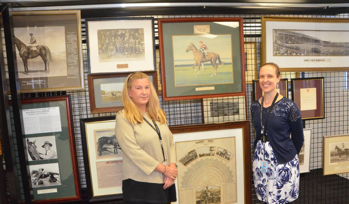 Margaret Helback and Hannah Hibbert with some of the magnificent paintings at the ATC Heritage Centre. Photo by Virginia Harvey