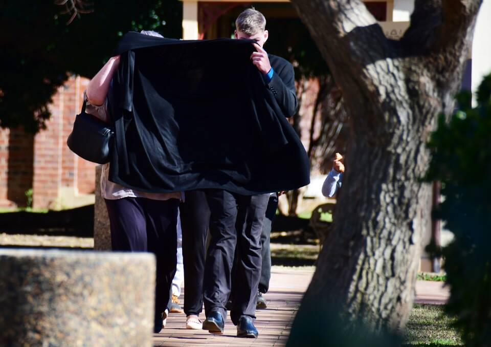 DUCKING FOR COVER: Alleged emu plucker Jye Leslie Schultz tries to cover his face up as he leaves Dubbo court. Photo: BELINDA SOOLE