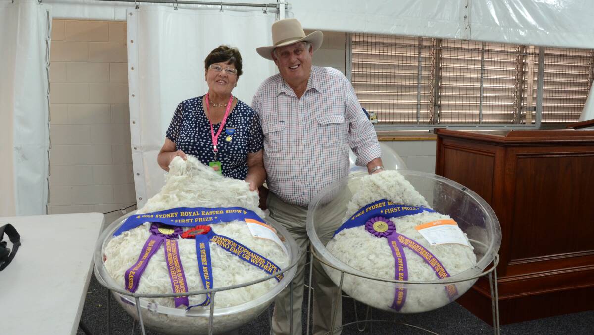 Lorraine and Ian Hills, Leawarra, Guyra, with two of their winning topmakers fleeces including the champion Merino ram fleece and champion Merino ewe with the ewe fleece winning the Brian Devereux Memorial Trophy.