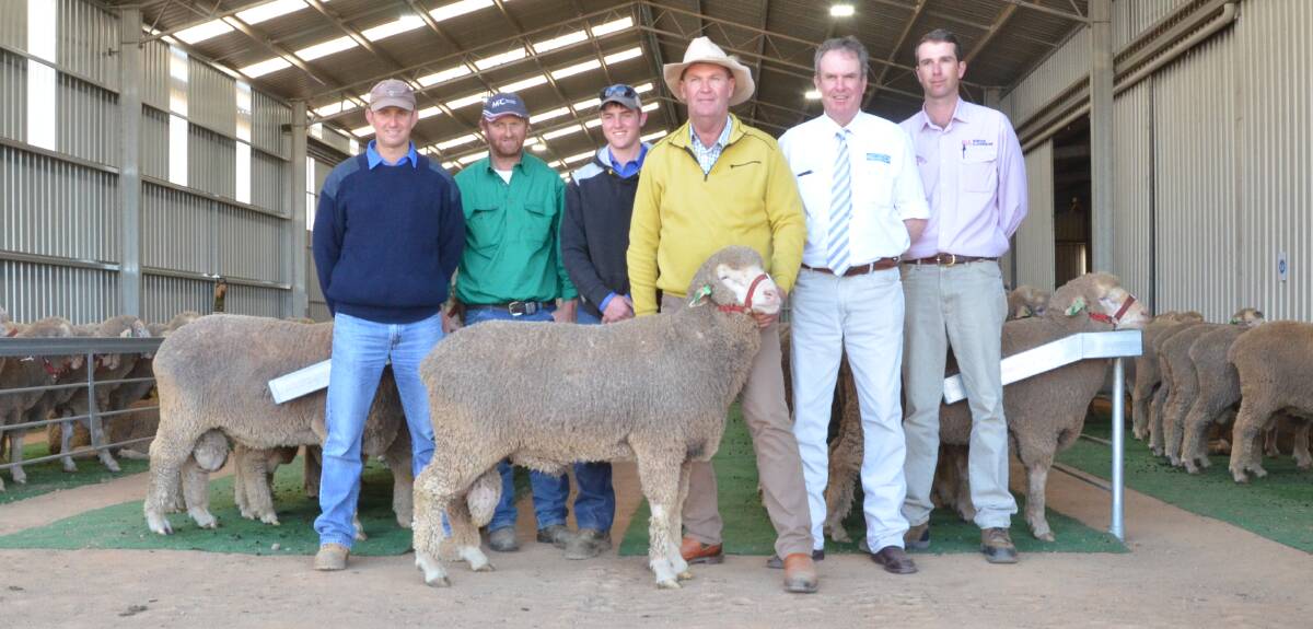 The $10,000 sale-topper, a 19 micron ram purchased among 26 for a $4058 average by the Wykes family, Mount Top, Euchareena, with buyers Brett, Murray and Alan Wykes, Kerin Poll studmaster Nigel Kerin holds the ram with auctioneer Paul Dooley, Tamworth and Todd Clements, Bowyer and Livermore, Bathurst.