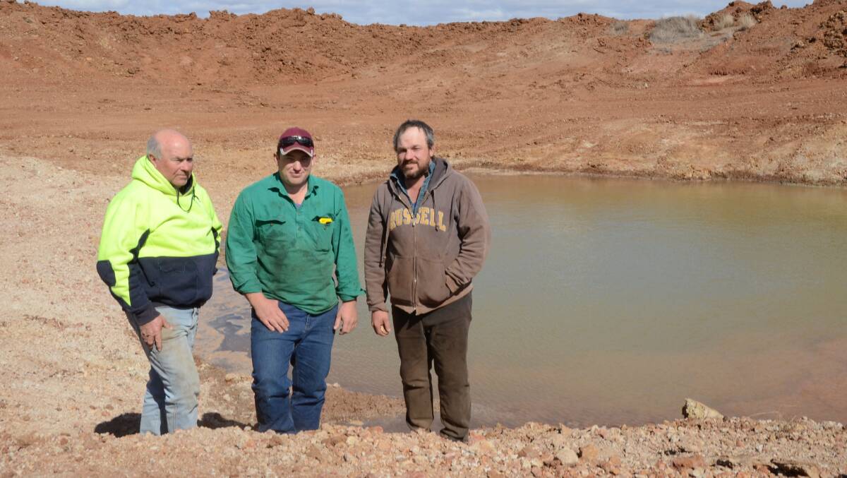 Don Mudford and sons, Scott and Robert near the base of a 3500 cubic metre dam recently cleaned out with an excavator and waiting for a tanker-load of freshwater to be delivered from a nearby bore at Parkdale, Dubbo.