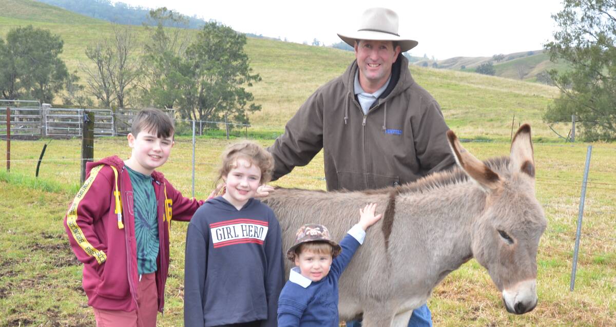 Siblings Noah, 11, and Leah Hyatt, 8, and Jesse Richards, 2, with Justin Richards, say goodbye to their favourite, Pedro the donkey, which sold for $2700 last Saturday.