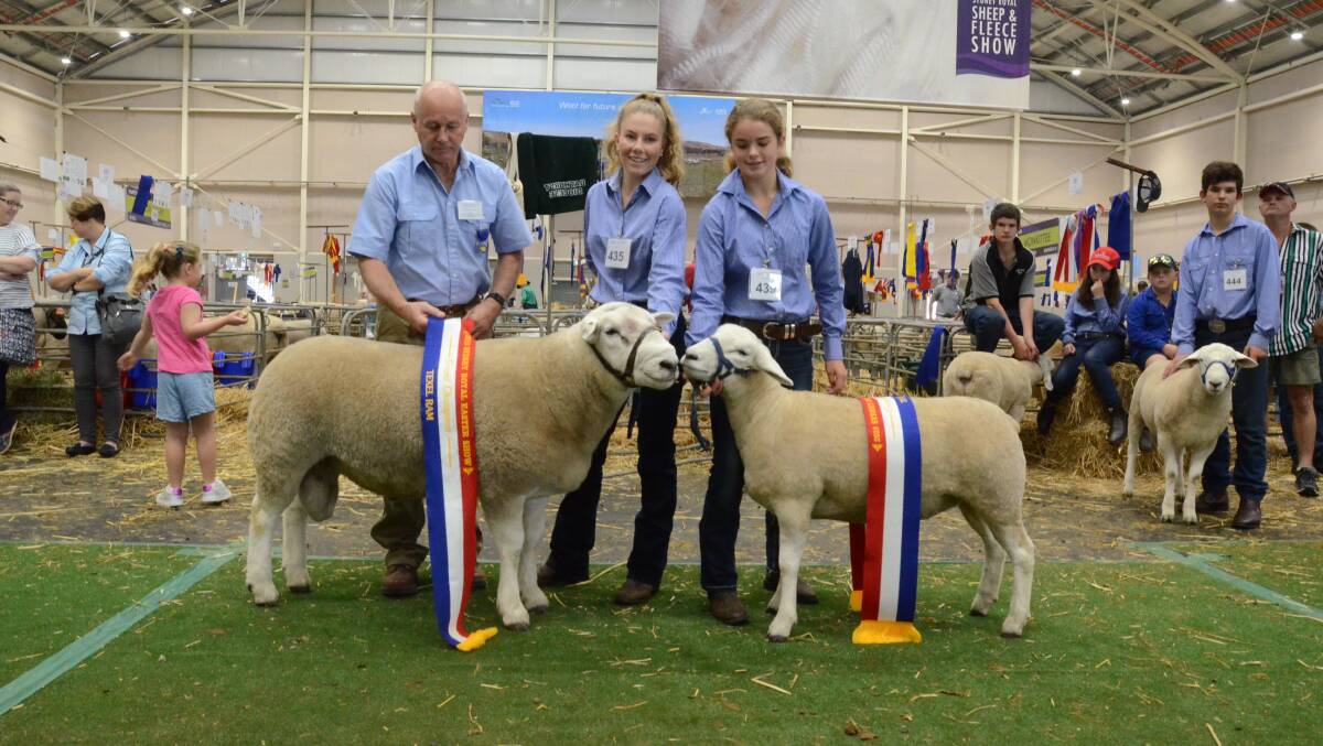 Judge, Peter Shepherd, Wheeo, Crookwell, sashes grand champion Texel ram held by Willough Corby while Isabella Hindmarsh holds the grand champion ewe.