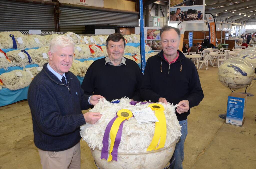 Supreme champion fleece exhibited by Merryville stud, Boorowa. Pictured is co-judge, John Croake, AWN, Tamworth, with exhibitors Wally and George Merriman.