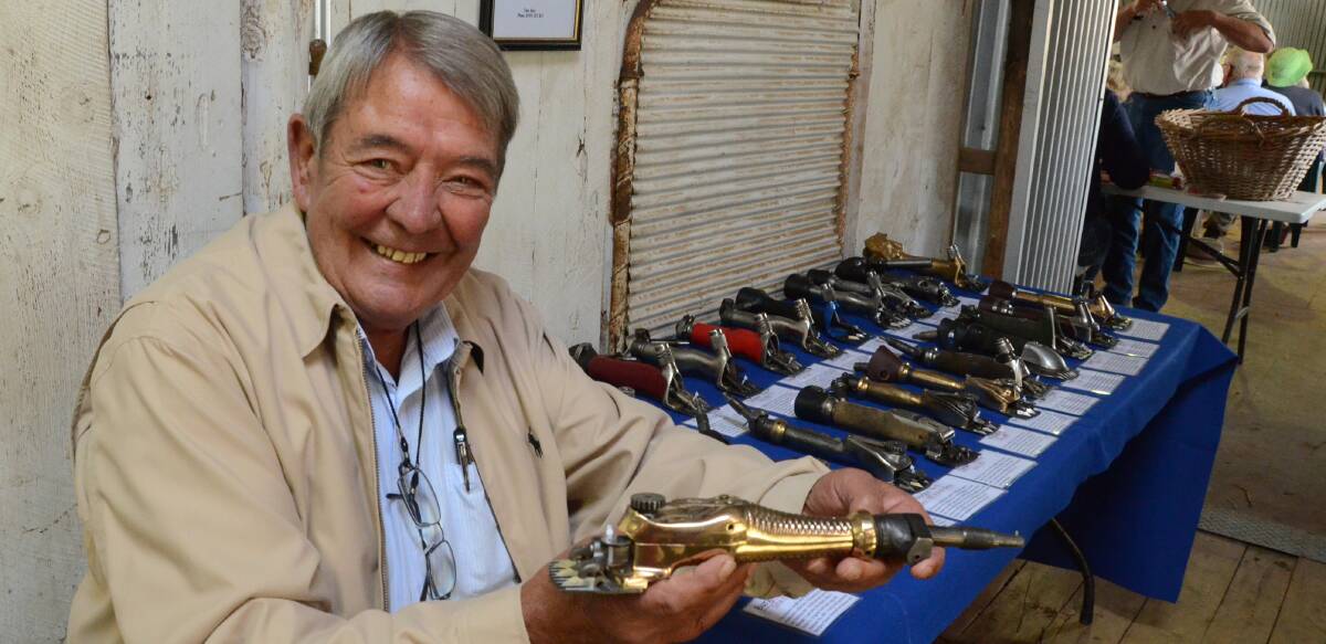 Tony Abra displays some of his 250 shearing handpieces in the collection he started as a hobby in 2002 and holds a 1900 brass Burgon Daisy.
