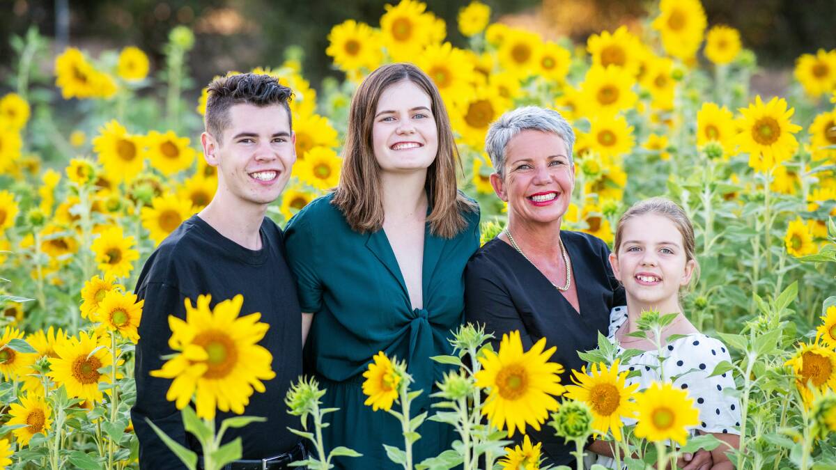 Accidental gardener/town promoter, Kylie Davis with children Patrick, Shelby and Elisa in their sunflowers that have brightened the lives of many. Photo: Zowie Photography