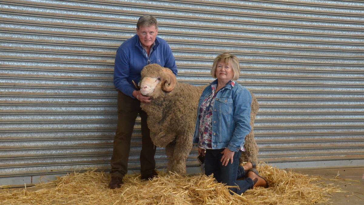 Darriwell stud principals Russell and Jennifer Jones, Trundle, hold their $10,000 ram purchased through AuctionsPlus.