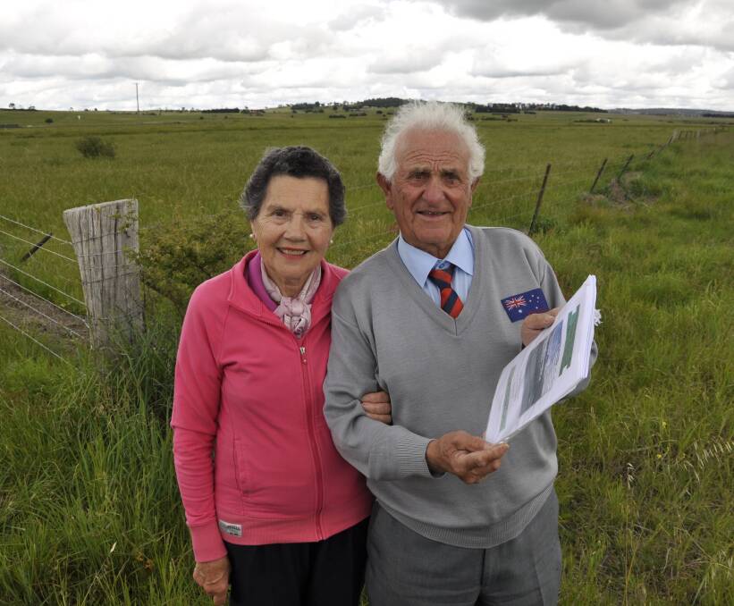 IN THE WIND: Tony and Adrianna Lamarra have big plans to establish an aeropark on land they own adjacent to Goulburn airport, pictured behind. The Lamarras want to draw business back to the city.