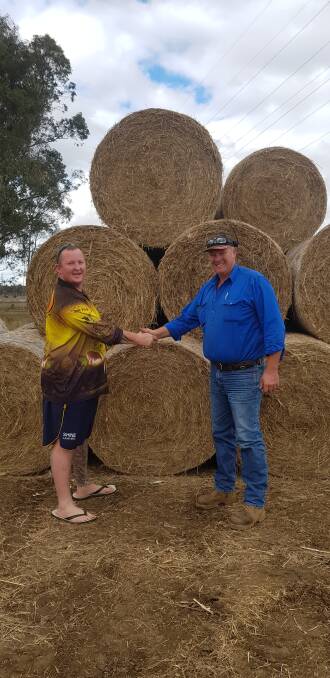 Adam Memorey with the hay vendor, Chris O'Shea, who donated eight of the large round bales.