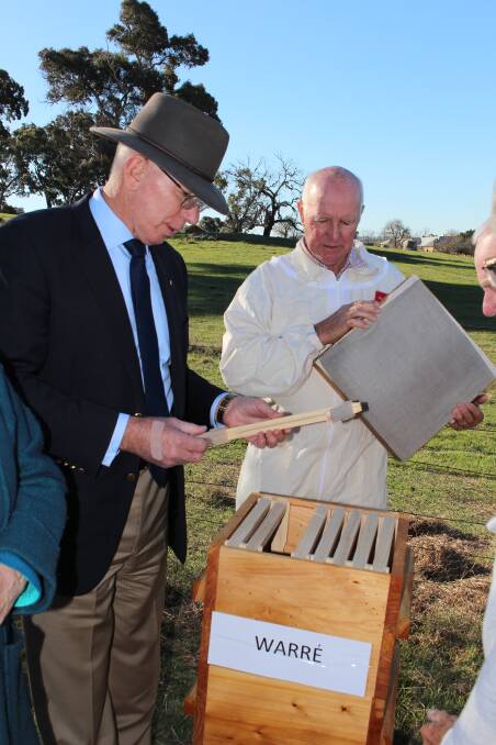 INSPECTION: Governor Hurley, and Greg Weekes take a look at a Warre beehive.