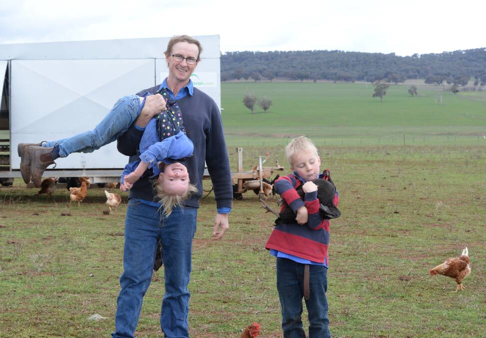 FAMILY FUN: Rodger, Willamina and Charlie Shannon spend time with some of their 2000 free range chickens. Photo: Rachael Webb.