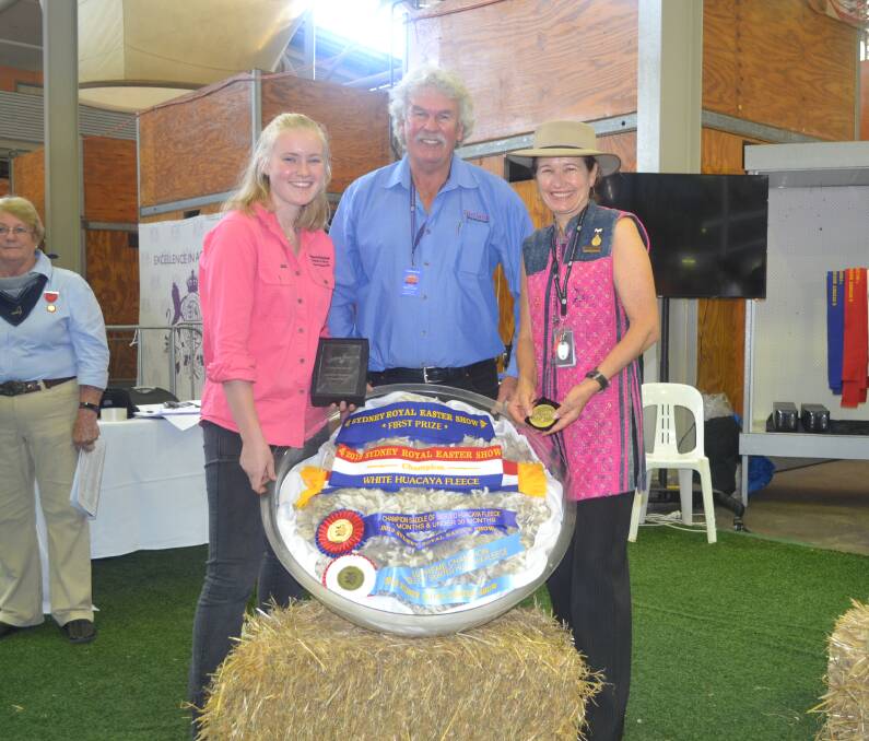 Coolawarra & Storybook Alpacas' Rubey Williams and Janie Forrest are presented the Supreme Huacaya Fleece ribbon by Ian Preuss. 