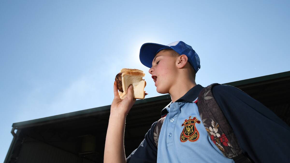 The right bite: Daniel Loftus from St Mary's in Gunnedah hooks into one of 5000 Murray Grey steak sandwiches sold at Agquip this year. Photo: Gareth Gardner 