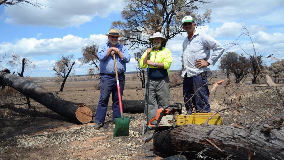 BLAZEAID: Volunteers David Staniforth and Glen Fletcher, and property owner Stirling Fergusson spent Monday ripping out damaged fencing. Photo: ELOUISE HAWKEY