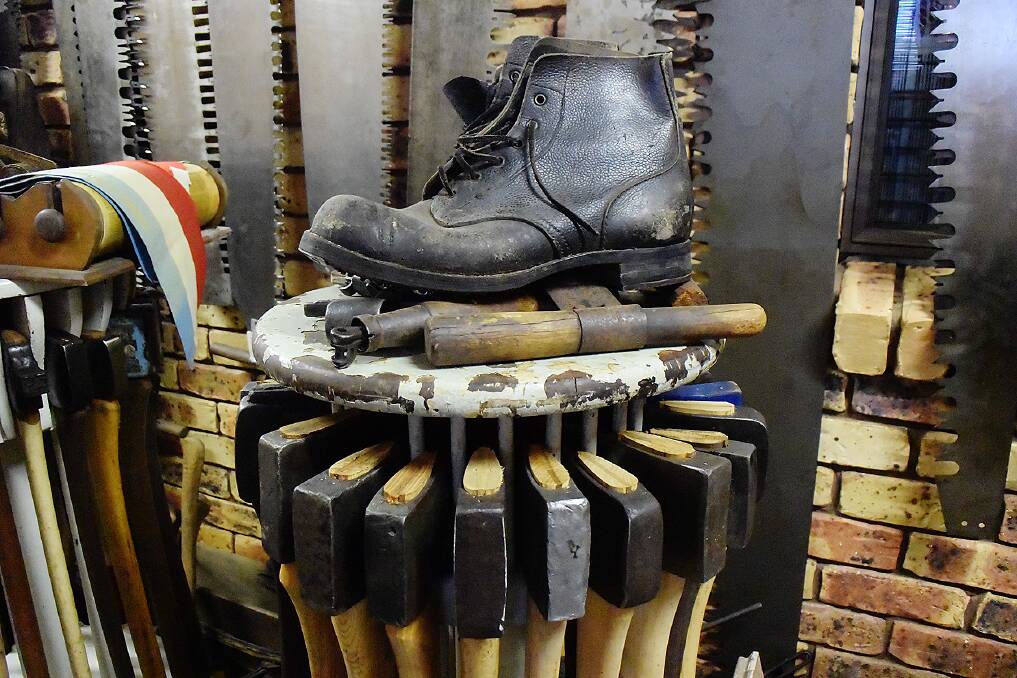 An old hobbled boot among racing axes and competition crosscut saws.