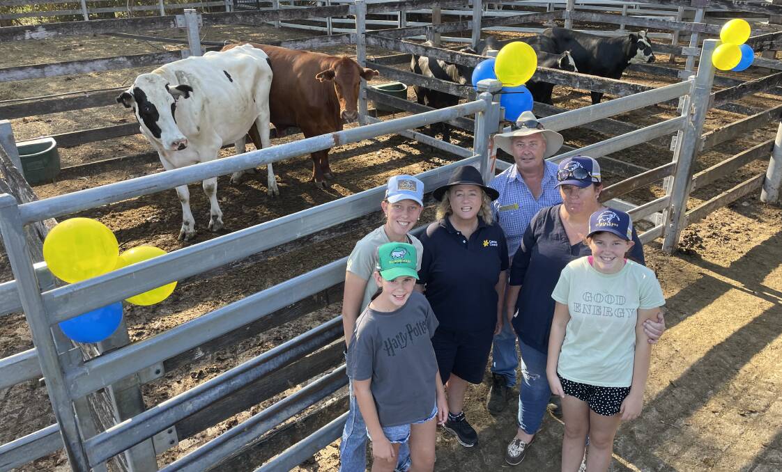The charity steer, kept calm with its dairy coacher, donated by the Sutherland family - who have raised more than $35,000 for cancer research in seven years - did well to make 370 cents a kilogram for 645kg or $2386.50, with Izzy and Zoe Sutherland, Christine Williams from the Cancer Council, Darren, Bec and Amelya Sutherland at Kempsey on Thursday.