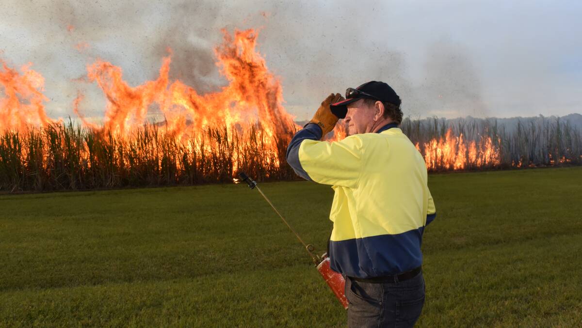 Mark Gittoes, Broadwater, shields his face from the intense heat of a sugar cane fire prior to harvesting. As a supplier to Northern Rivers' co-operative Sunshine Sugar, Mr Gittoes is fortunate that his sugar has been forward sold this season, and that the NSW Sugar Milling Co-operative is proactive in finding alternative markets for its commodity product other than export.