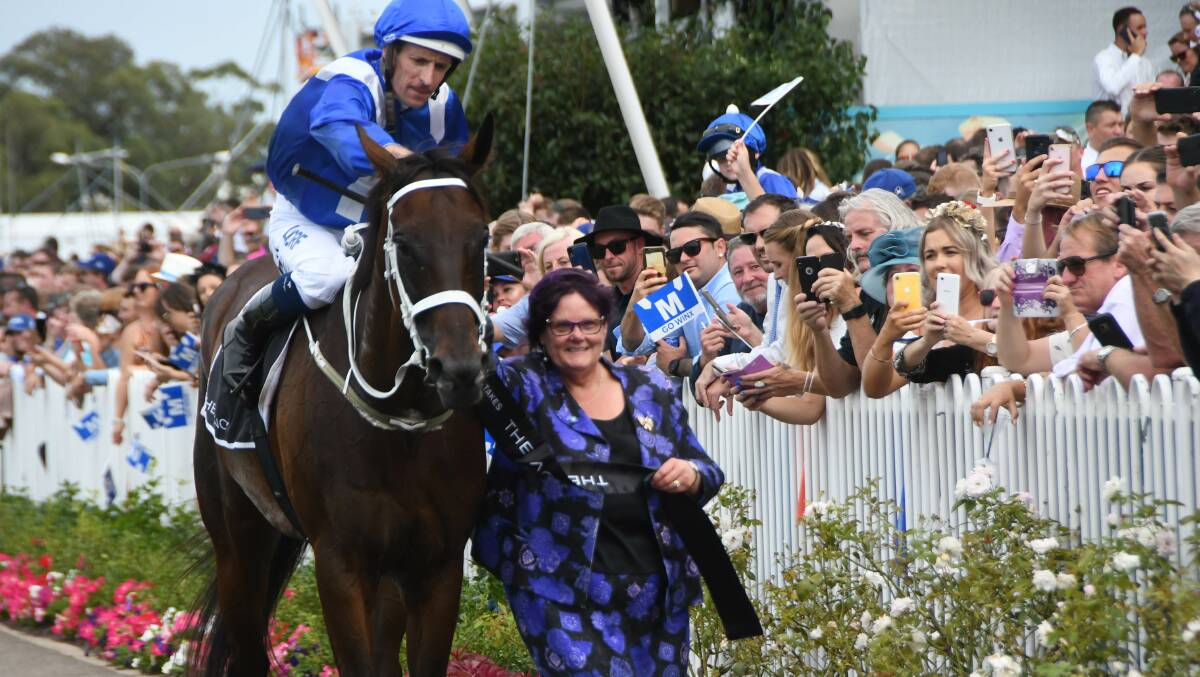 Part-owner Debbie Kepitis leads Winx back (with Hugh Bowman aboard) after her 32nd successive win in front of a massive crowd at Rosehill on Saturday. Photo Virginia Harvey