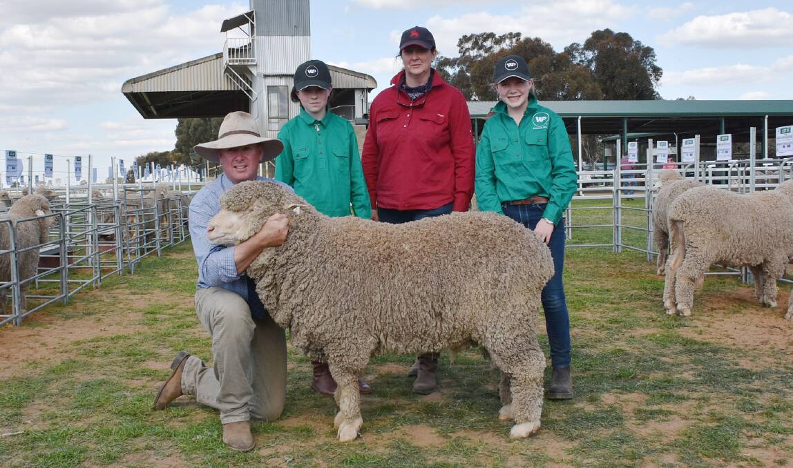 Stephen Huggins holds the $5750 second top price ram purchased by Edwina and Sue Braid, Frogmore, while Woodpark's Olivia Huggins looks on.