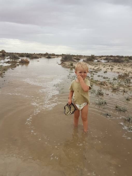 Bill O'Connor's grandson Caine standing in the Bulloo overflow flood water. Photo supplied. 