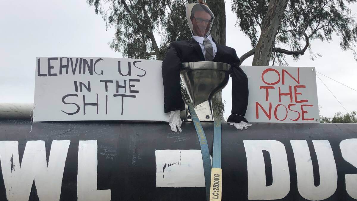 Much of the anger at the rally was directed towards federal Water Resources Minister, David Littleproud. This effigy of him was placed in a toilet on a truck with "Food Bowl - Dust Bowl' written on it before the effigy was thrown into the Murray River. 