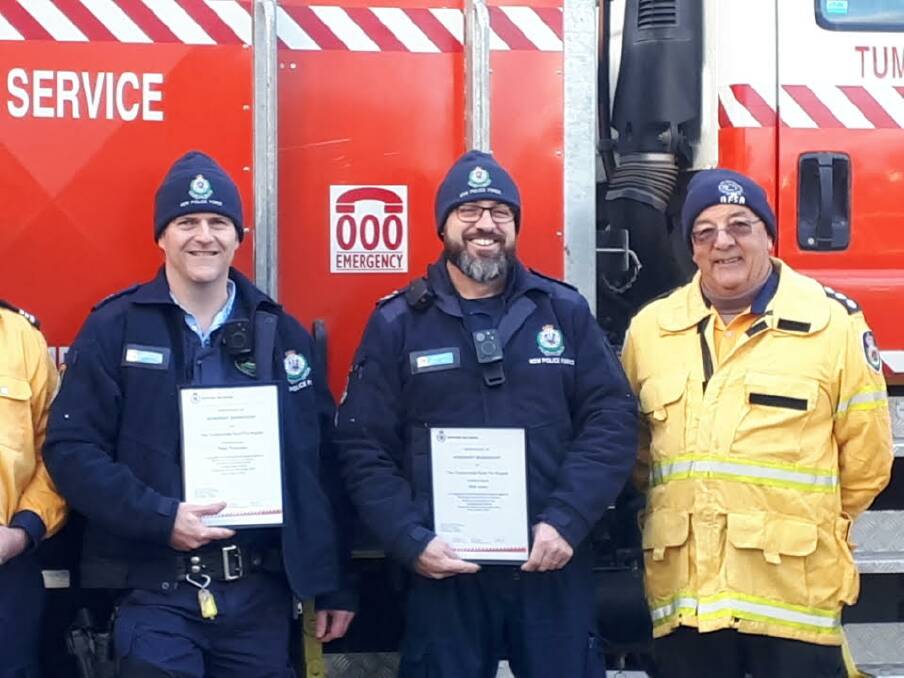 NSW RFS group captain Ian Pratt with senior constables Peter Thompson and Mick Jones, who worked with Mr Pratt during the fires and were made honouree members of the brigade. Photo: Supplied 