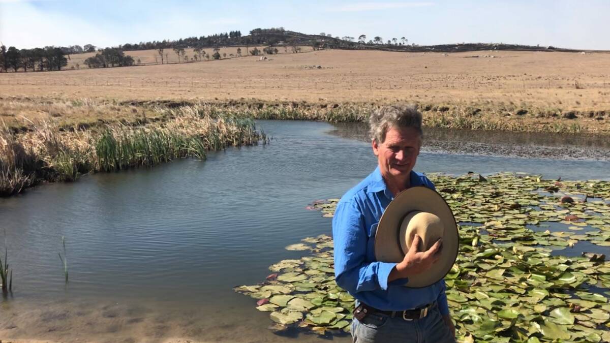 Martin Royds, Jillamatong, Braidwood, in front of one of his weirs, with the hills that were burnt out by the recent bushfires in the background. 
