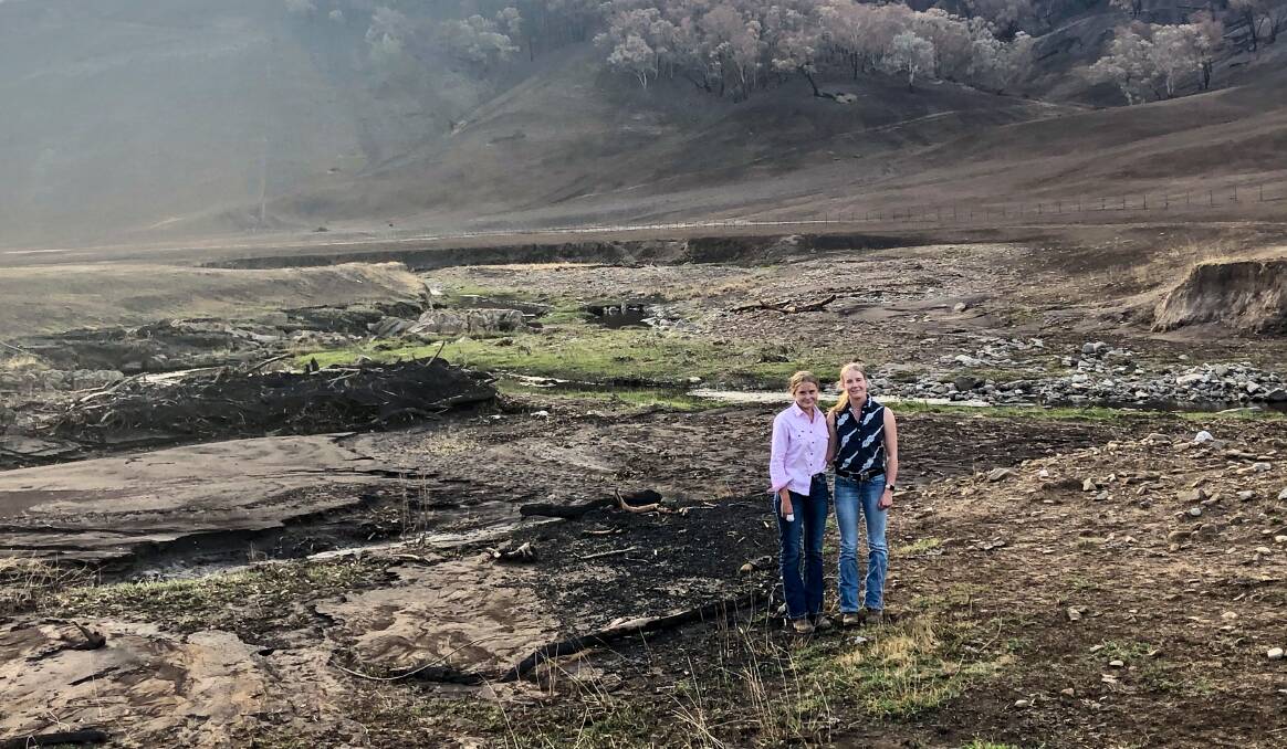 Rob Bulle's daughters Bec and Ali on one of the family's properties that was hit by both fire and floodwaters. Rebuilding after fire was interrupted by tsunami-like flash flooding. 
